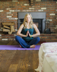 Portrait of woman sitting on wooden floor