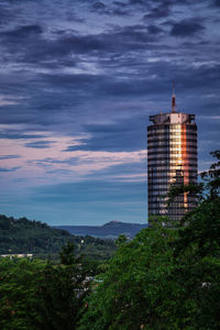 Low angle view of skyscrapers against cloudy sky