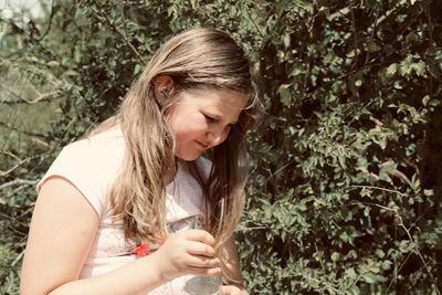 Close-up of a young woman holding plant