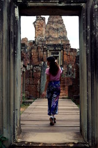 Rear view of woman walking by historical building