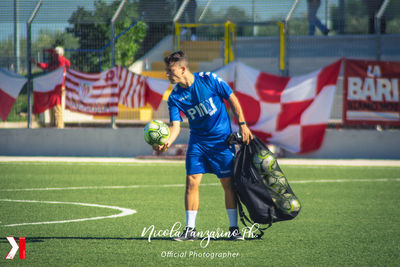 Full length of man playing soccer on grassland