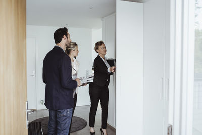 Real estate agent showing property to couple at new house