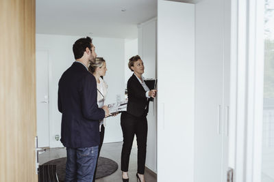 Real estate agent showing property to couple at new house