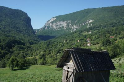 Scenic view of green landscape and mountains against sky