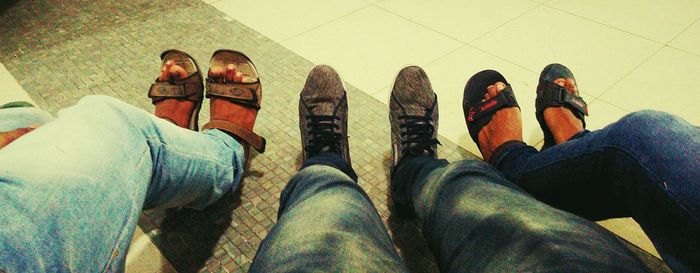 Low section of man standing on tiled floor