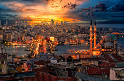 Illuminated cityscape against sky during sunset