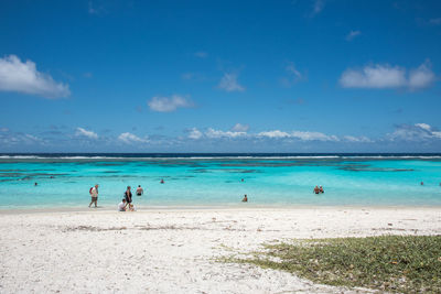 People at beach against sky