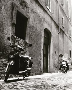 Low angle view of motor scooters on street against building