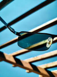 Low angle view of sunglasses against blue sky 