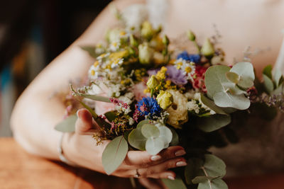 Midsection of woman holding bouquet