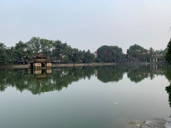 Scenic view of lake by trees against sky