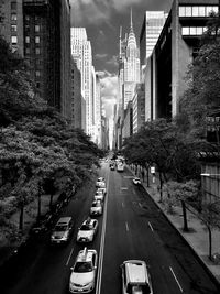 Vehicles on road amidst buildings in city