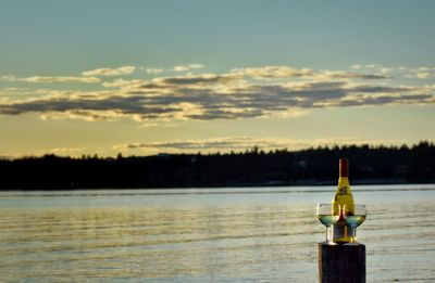 Close-up of bottle against calm sea