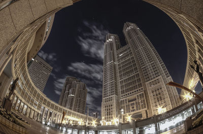 Low angle view of illuminated tower against sky at night