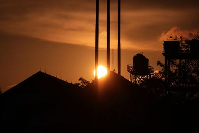 Silhouette built structure against sunset sky