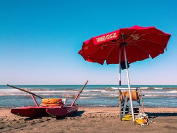 Deck chairs on beach against clear sky