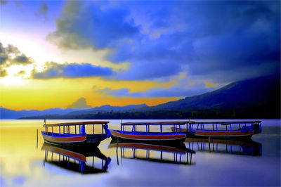 Boat moored on shore against sky during sunset