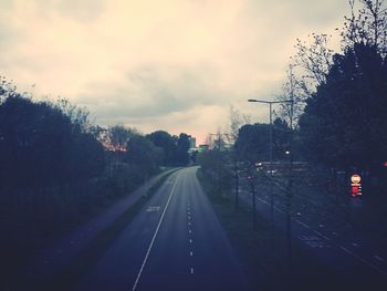 Road amidst trees against sky