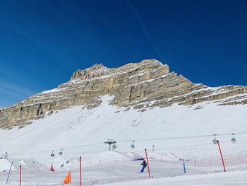 Scenic view of snowcapped mountains against clear blue sky