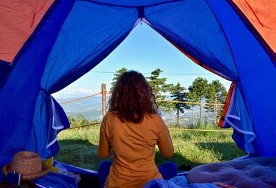 Rear view of people standing by tent against sky