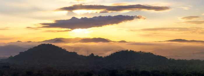 Scenic view of silhouette mountains against sky at sunset