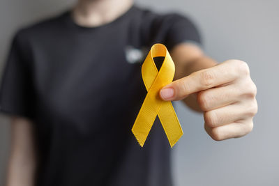 Close-up of hand holding yellow flower