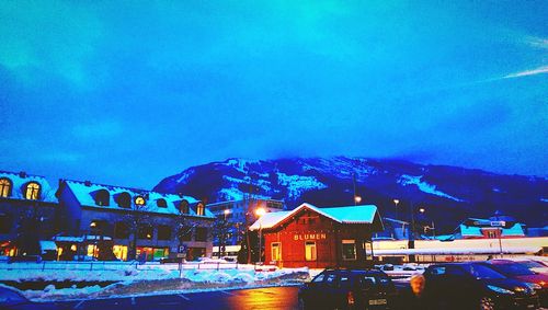 Illuminated town against blue sky in winter