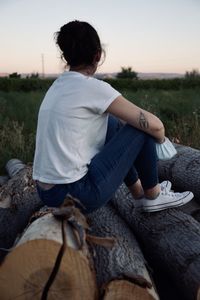 Rear view of woman sitting on rock