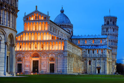 Illuminated pisa cathedral and leaning tower of pisa against clear sky at dusk