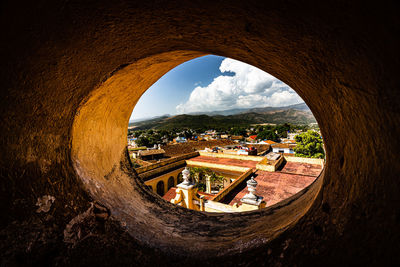 Scenic view of buildings seen through hole in window