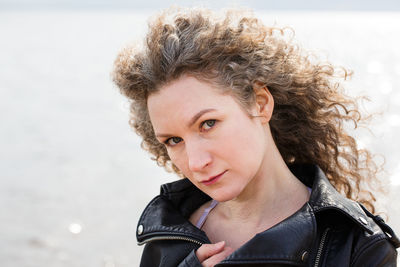 Portrait of a curly woman on the background of the bay