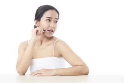 Portrait of a smiling young woman over white background