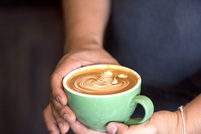 Midsection of man holding coffee cup