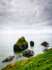 Rock formation in sea against sky