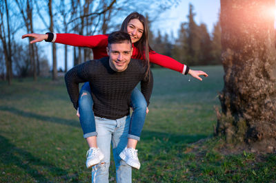 Man carrying girlfriend on back at park