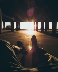 Rear view of people sitting on floor against sky during sunset