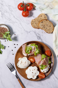 Delicious breakfast or snack - poached egg and cream cheese toast whole grain rye bread, prosciutto