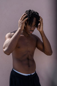 Young black man next to the pink wall portrait