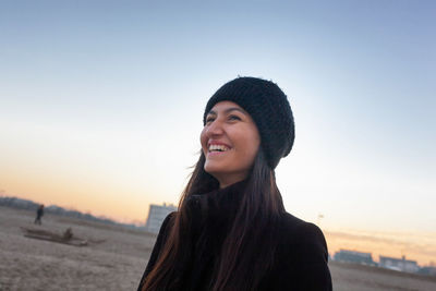 Portrait of smiling young woman against sky during sunset