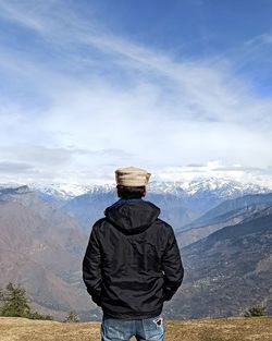 Man looking at mountains against sky