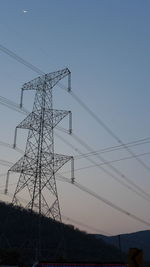 Low angle view of electricity pylon against clear sky