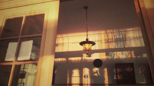 Low angle view of illuminated lamp hanging on window