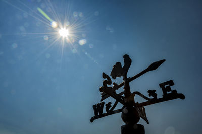 Low angle view of silhouette sign against sky on sunny day