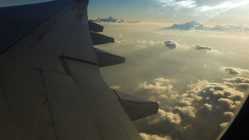 Cropped image of airplane over cloudy sky