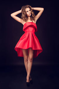 Portrait of a beautiful young woman over black background