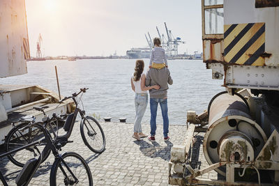 Germany, hamburg, family having a break from a bicycle tour at river elbe