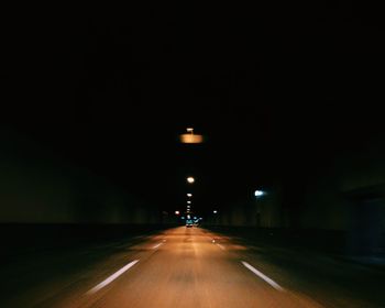 Illuminated road in tunnel at night