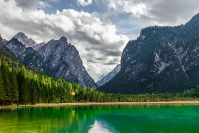 Scenic view of lake by mountains against sky