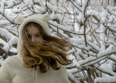 Close-up portrait of a young woman in snow