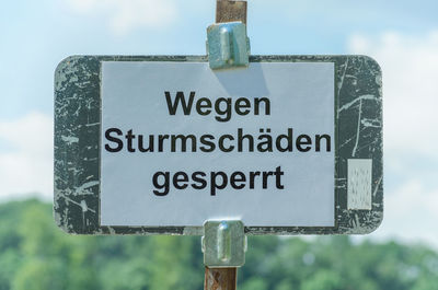 Information sign against sky